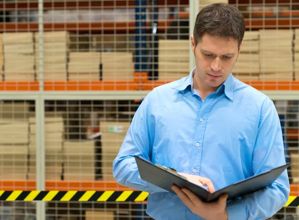 Handsome manager with clipboard in post office. — Stock Photo, Image