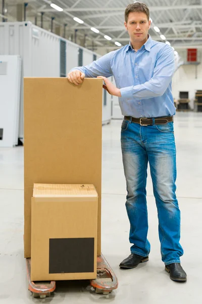 Male worker with boxes at warehouse. — Stock Photo, Image