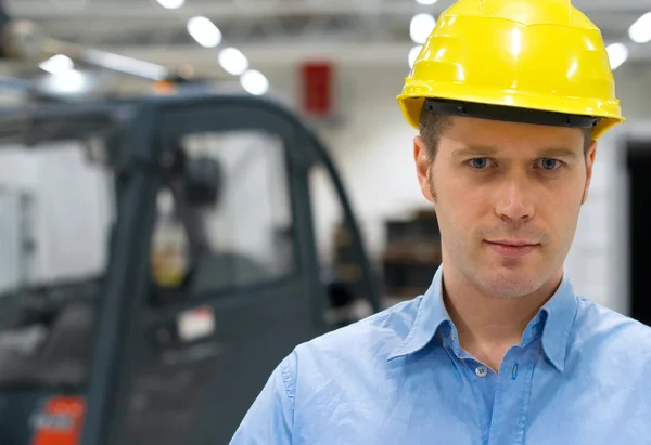 Warehouseman en amarillo casco en el almacén . — Foto de Stock