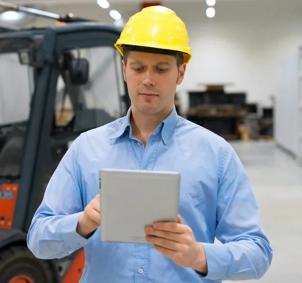 Warehouseman in hard hat with tablet pc at warehouse. — Stock Photo, Image
