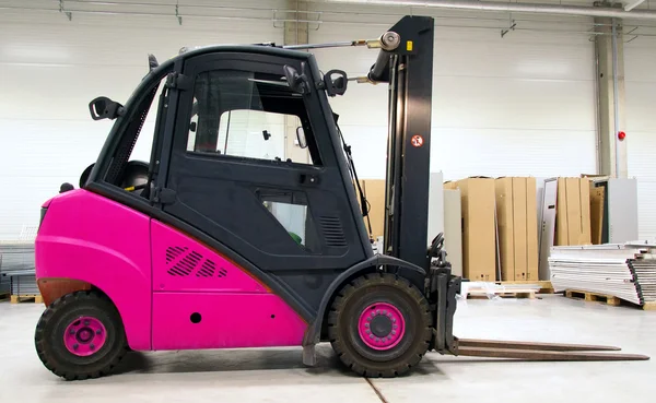 Carregador de empilhadeira rosa no grande armazém moderno . — Fotografia de Stock