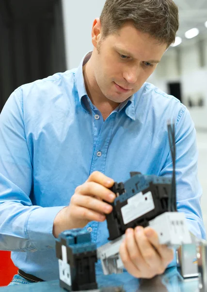 Trabajador guapo ensamblando componentes electrónicos en la fábrica . — Foto de Stock