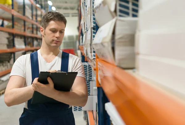 Supervisor with clipboard checking barcode at the warehouse. — Stock Photo, Image