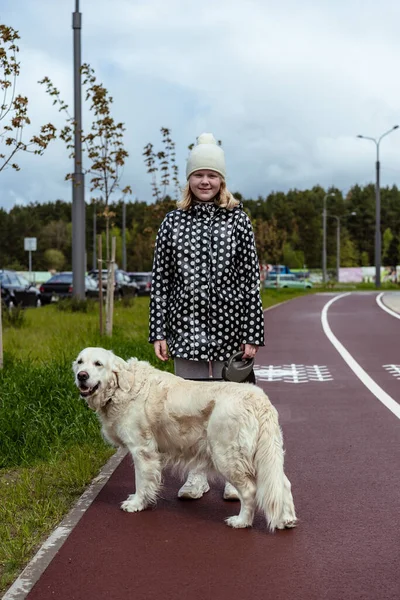 Pandemia de coronavirus en la ciudad. chica caminando un perro golden retriever a lo largo de calles vacías —  Fotos de Stock