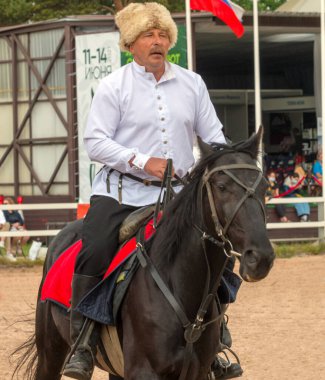 Kuban Kazağı at üstünde açık havada numaralar yapıyor. XXII Uluslararası Binicilik Sergisi Hipposphere. Saint-Petersburg - 13 Haziran 2021.