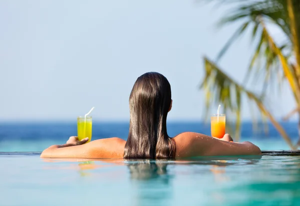 Bruna ragazza con cocktail in piscina — Foto Stock