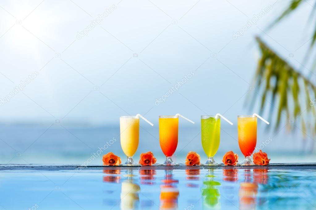 Cocktails drinks placed next to swimming pool