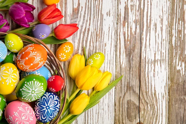 Ostereier und Tulpen auf Holzplanken — Stockfoto