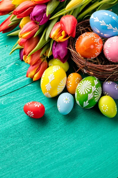 Huevos de Pascua y tulipanes sobre tablones de madera — Foto de Stock