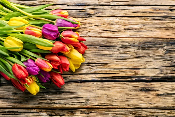Pisanki i tulipany na drewnianych deskach — Zdjęcie stockowe