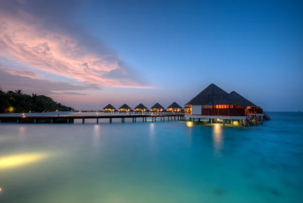 Villas aquatiques sur l'île de villégiature des Maldives au coucher du soleil — Photo