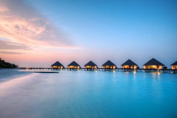 Villas aquatiques sur l'île de villégiature des Maldives au coucher du soleil — Photo