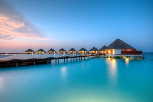 Villas aquatiques sur l'île de villégiature des Maldives au coucher du soleil — Photo