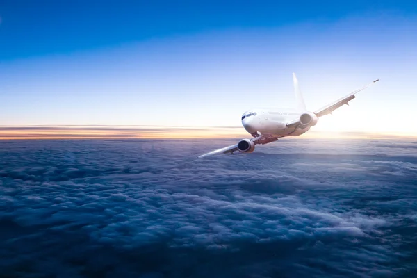 Commercial jet aeroplane flying above clouds — Foto Stock