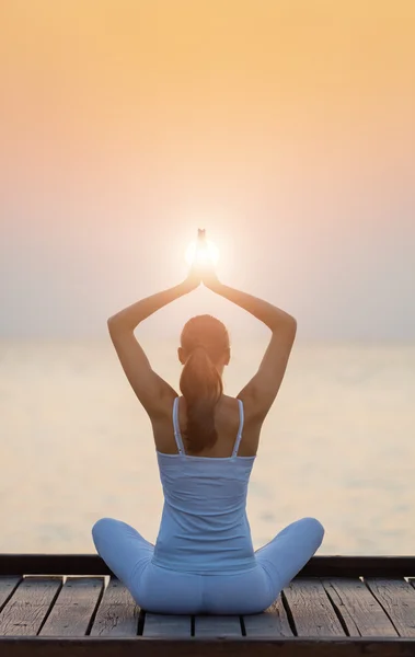 Mujer joven practicando yoga en la playa al atardecer — Foto de Stock