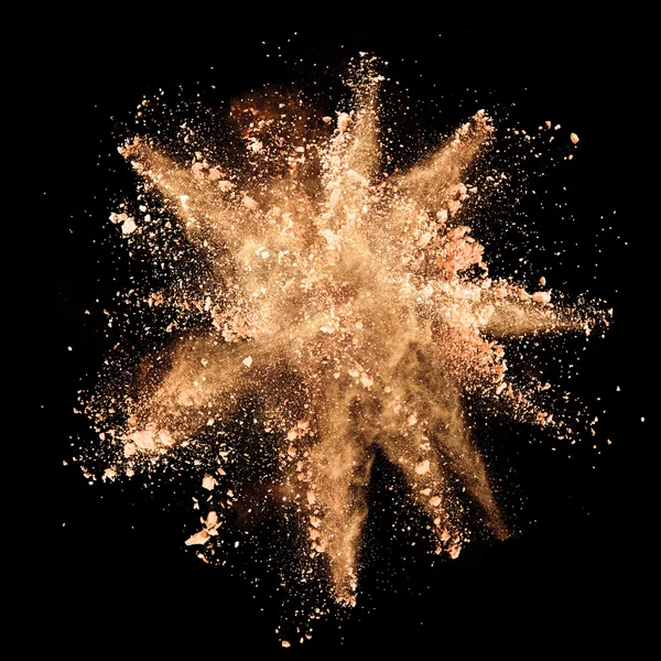 Explosion of brown powder on black background — Stock Photo, Image