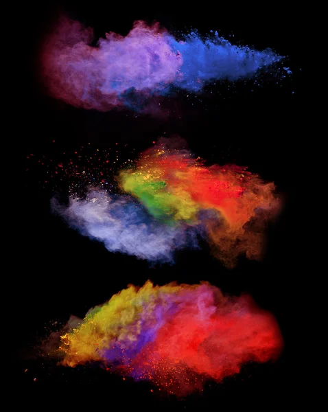 Explosions of colored powder on black background — Stock Photo, Image