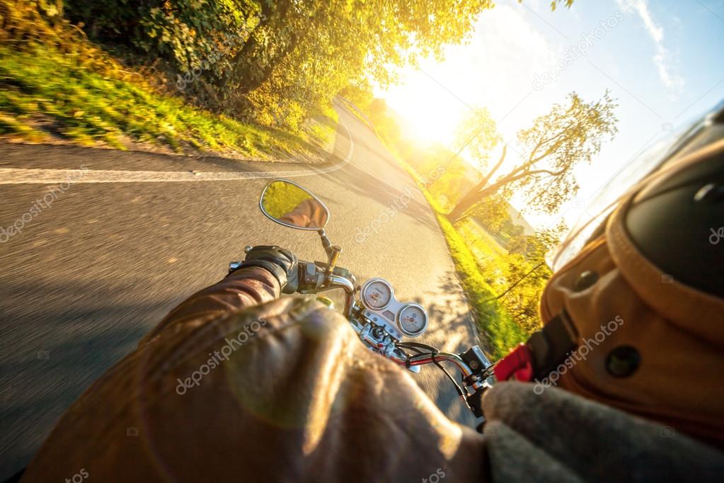 Motorcyclist riding motorbike in sunny morning