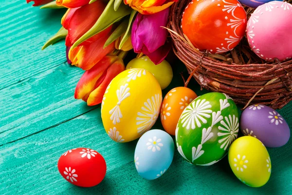 Huevos de Pascua y tulipanes sobre tablones de madera — Foto de Stock