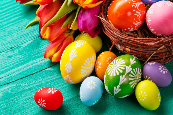 Easter eggs and tulips on wooden planks