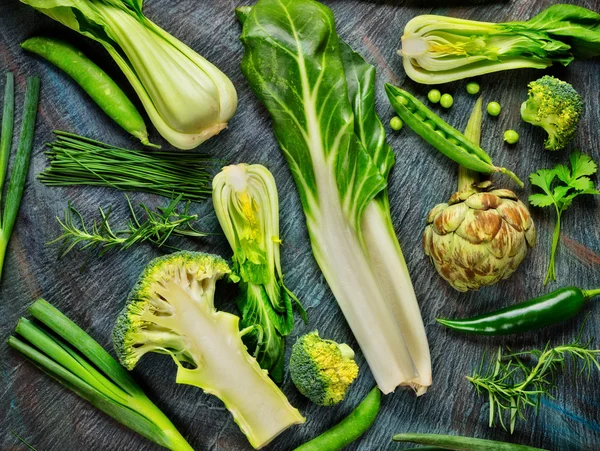 Raccolta di verdure verdi fresche su pietra nera — Foto Stock