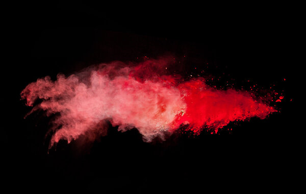Explosion of red powder, isolated on black background