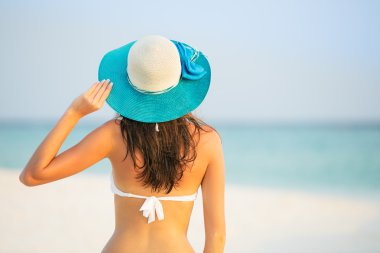 Tropik sahilde yürüyen genç kadın