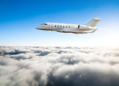 Özel jet uçak bulutların üzerinde uçan