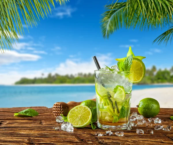 Летний напиток на фоне размытого пляжа — стоковое фото