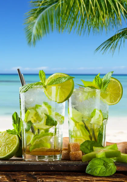 Летние напитки на фоне размытого пляжа — стоковое фото