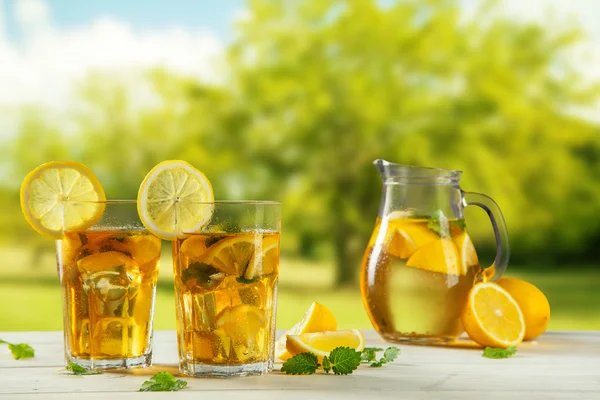 Cups of ice tea with trees on background — Stock Photo, Image