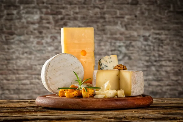 Various types of cheese placed on wooden table — Stock Photo, Image