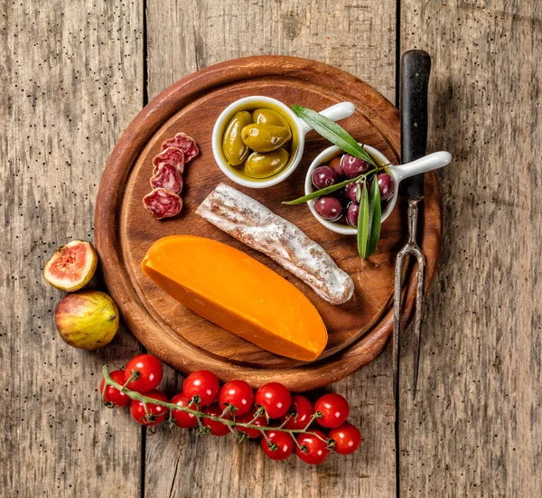 Various kind of cheese and delicacy on wood — Stock Photo, Image