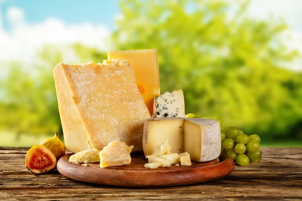 Various types of cheese placed on wooden table — Stock Photo, Image