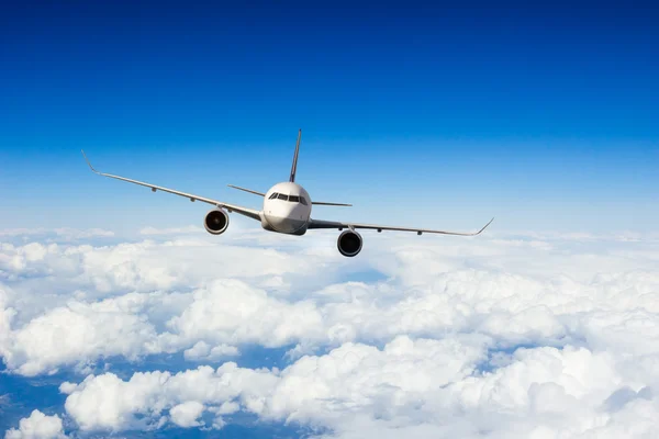 Commercial jet plane flying above clouds Stock Image