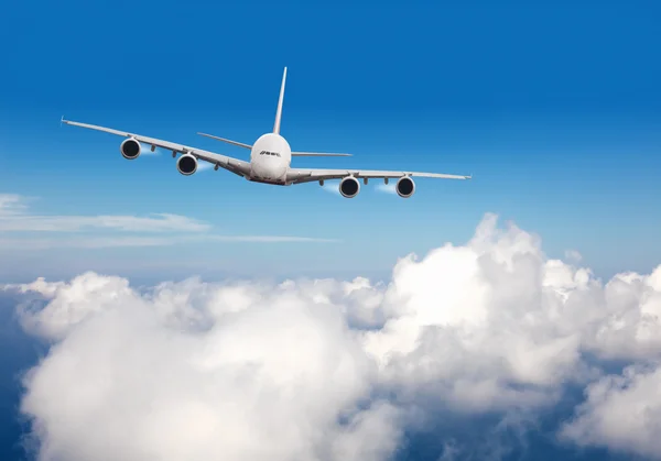 Комерційний реактивний літак, що летить над хмарами — стокове фото