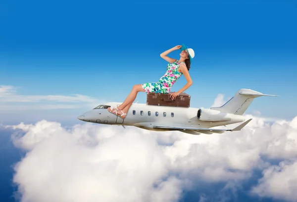 Mujer joven sentada en el avión sobre las nubes — Foto de Stock