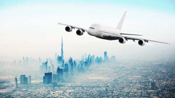 Commerciële vliegtuig vliegen over moderne stad — Stockfoto