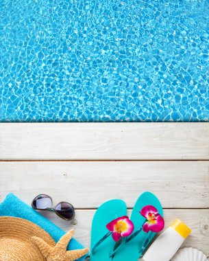 Havuzlu ahşap arka plan üzerinde plaj aksesuarları