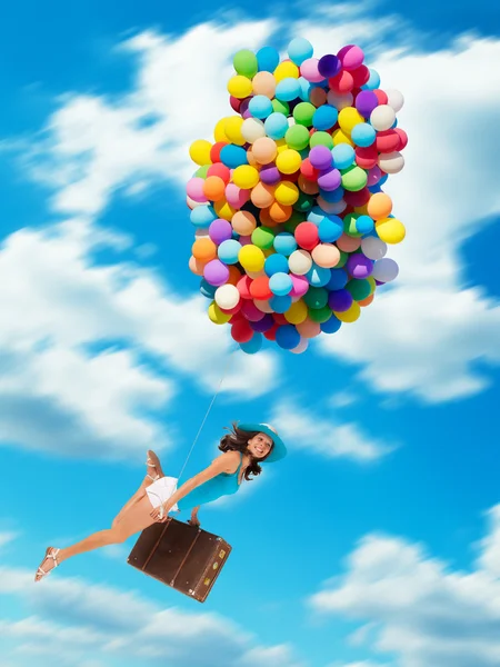 Femme tenant des ballons et volant au-dessus des nuages — Photo