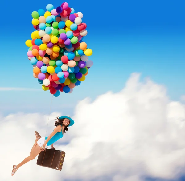 Mulher segurando balões e voando acima das nuvens — Fotografia de Stock