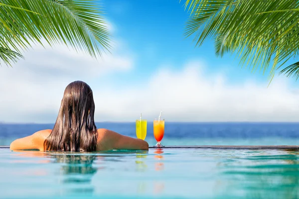 Chica morena con cócteles en la piscina —  Fotos de Stock