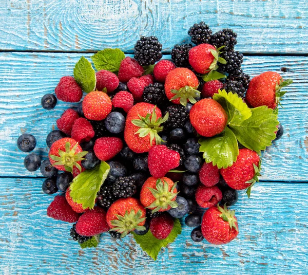 Verse bessen fruit stapel gelegd op oude houten planken — Stockfoto