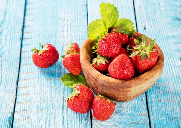 Strawberries in saucer, placed on old wooden planks — Stock Photo, Image