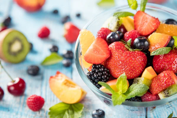 Ahşap masa üzerinde sunulan taze meyve salatası — Stok fotoğraf