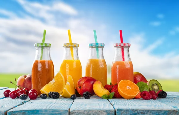 Suco fresco com mistura de frutas na mesa de madeira — Fotografia de Stock