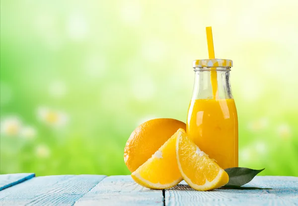 Sumo fresco com fruta de laranja na mesa de madeira — Fotografia de Stock