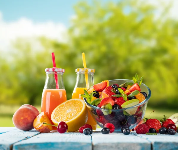 Färsk juice med frukt blanda på träbord — Stockfoto