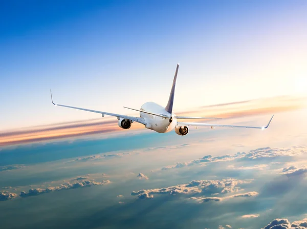 Flugzeug fliegt über Wolken in dramatischem Sonnenuntergang — Stockfoto