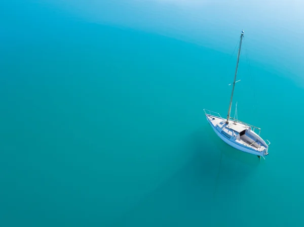 Vista aérea de iate sozinho navegando em água azul — Fotografia de Stock